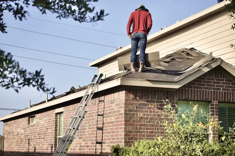 Professional roofer working on a residential roof in Bluemont